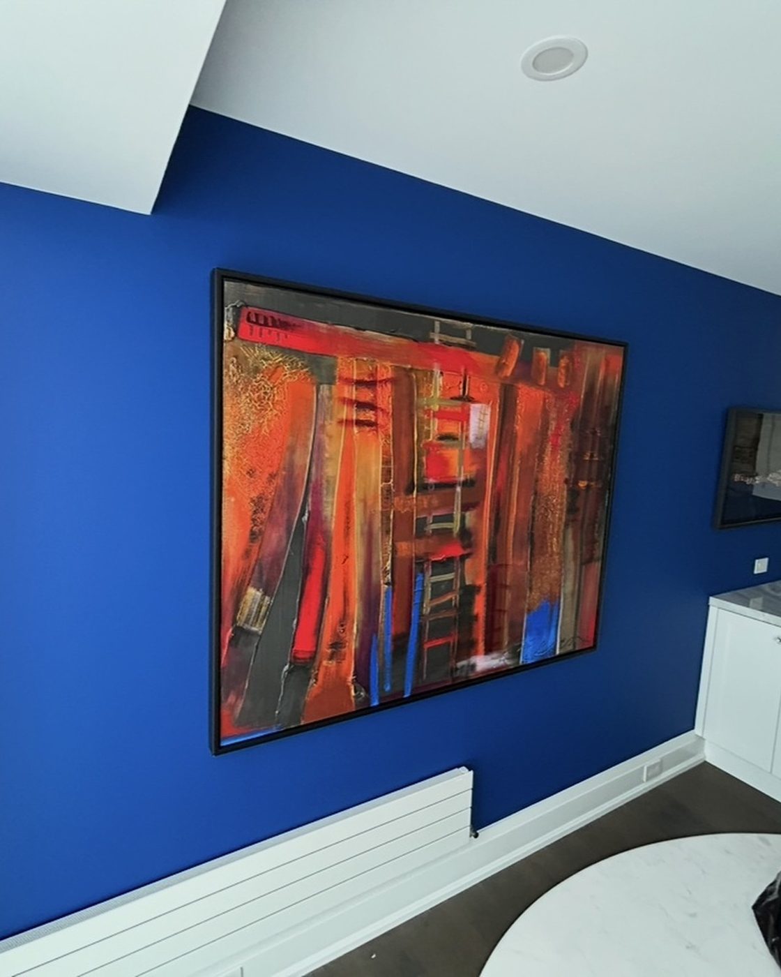 Kitchen wall after, bold blue accent wall with artwork