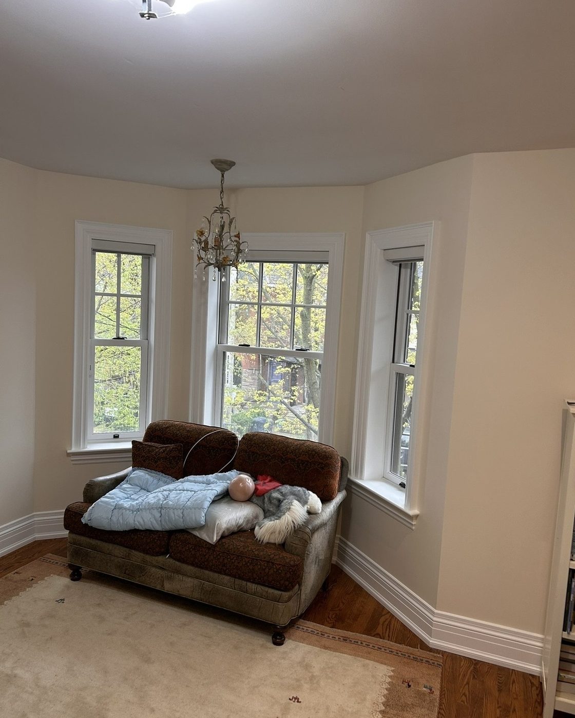 Bedroom after, freshly painted warm neutral walls in bay window sitting area
