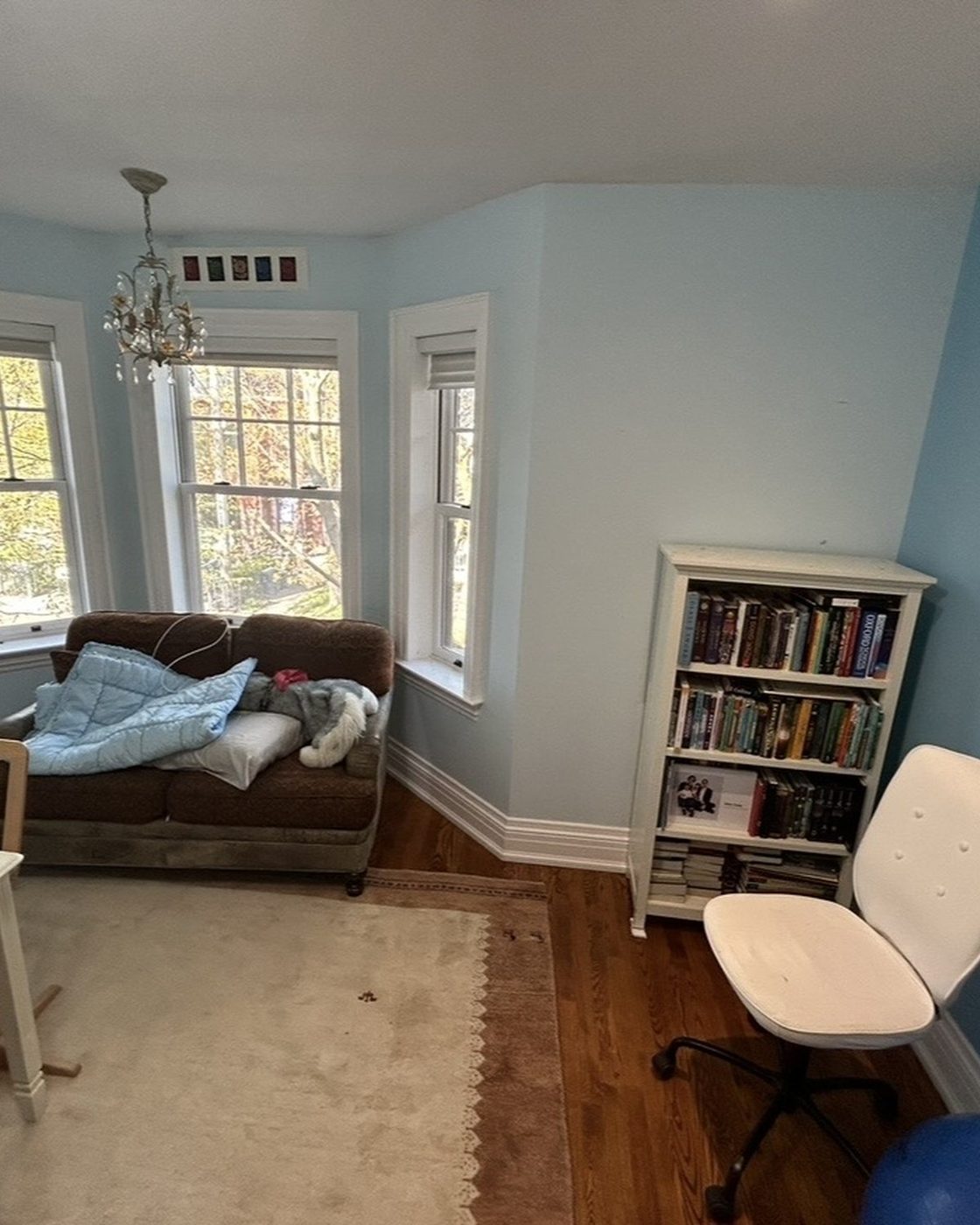 Bedroom before, pale blue accent walls in bay window sitting area