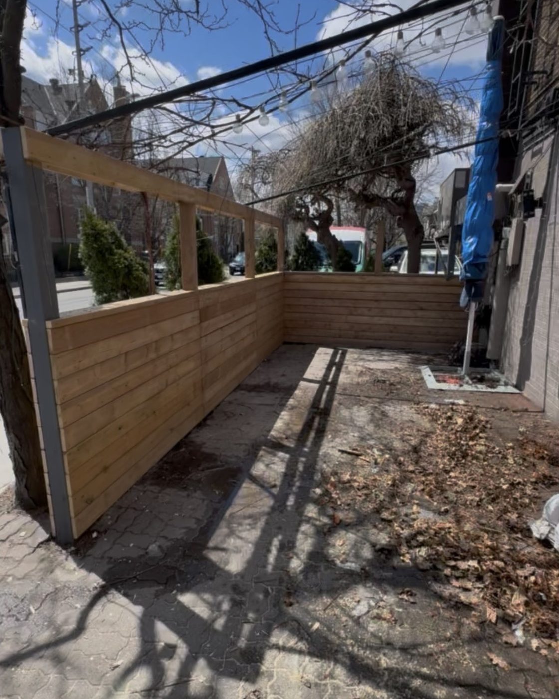 Patio fence before, bare untreated wood pergola and privacy wall