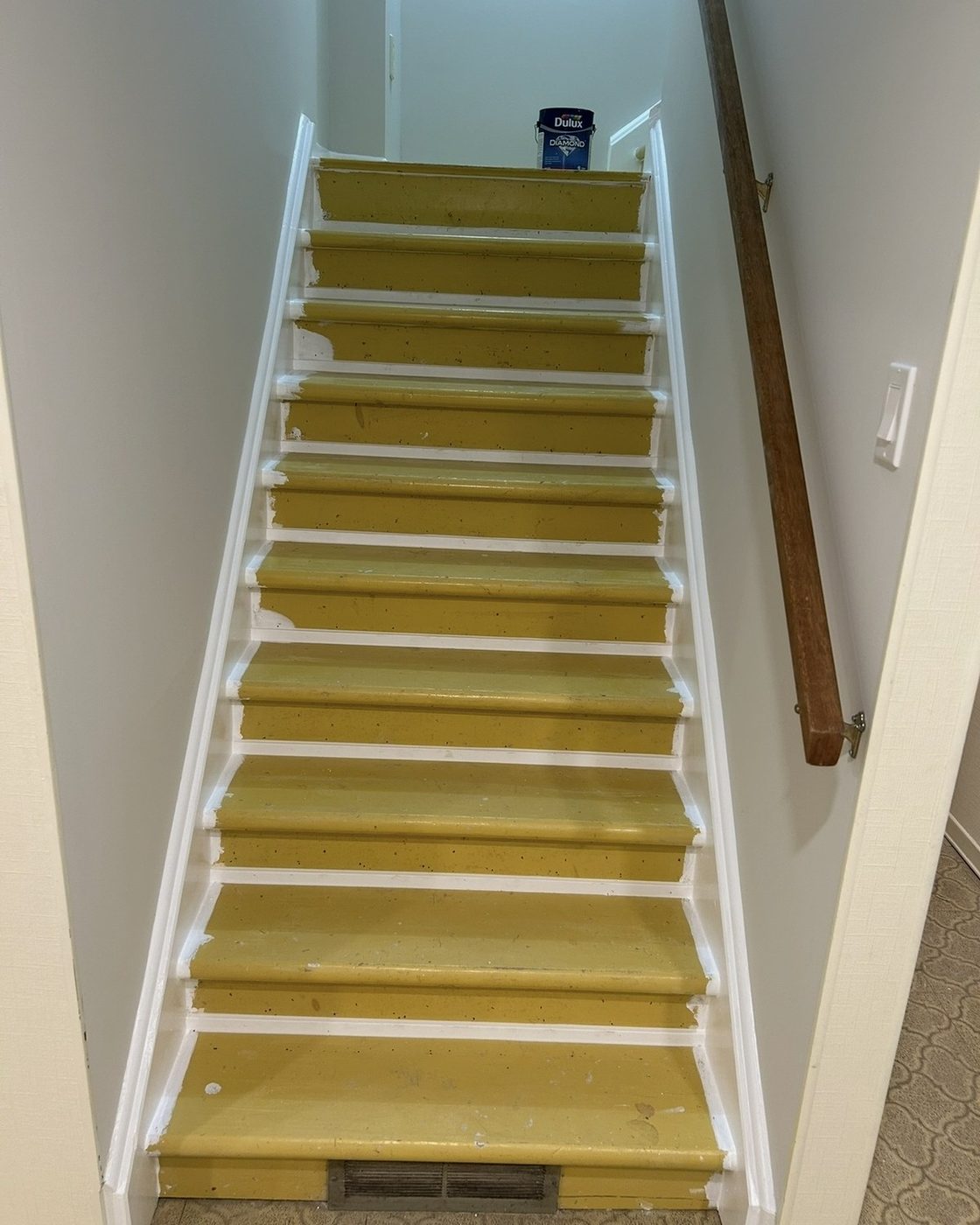 Staircase before refinishing, bare plywood treads with worn underlay